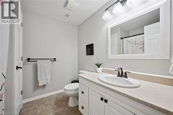Bathroom vanity featuring a white cabinet, integrated sink, and light-toned countertop - 