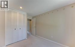 Bedroom featuring light-toned walls with an ornamental border and soft carpeting - 