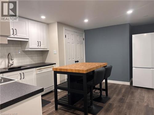 Kitchen featuring white cabinetry with dark hardware, dark countertops, and a subway tile backsplash - 4187 Weimar Line, Wellesley, ON - Indoor