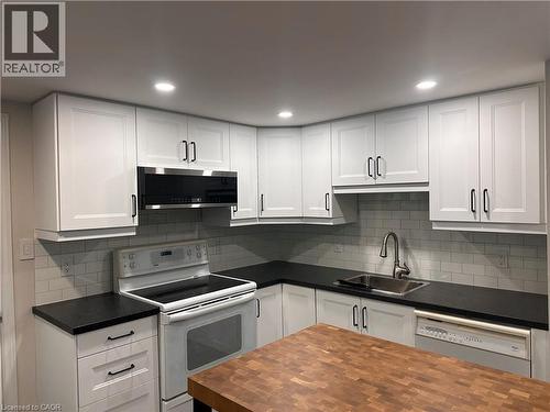 Contemporary kitchen featuring white shaker cabinetry with matte black hardware, dark countertops, and a subway tile backsplash - 4187 Weimar Line, Wellesley, ON - Indoor Photo Showing Kitchen