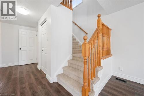 Carpeted staircase with wood banister and balusters - 71 Peach Blossom Crescent, Kitchener, ON - Indoor Photo Showing Other Room