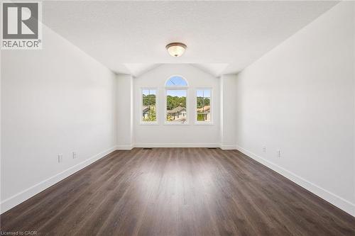 Spacious room featuring wood-finish flooring, white baseboards, and a vaulted ceiling - 71 Peach Blossom Crescent, Kitchener, ON - Indoor Photo Showing Other Room