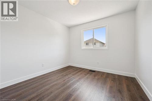 Bright room featuring wood-finish flooring, white walls, and a window with white trim - 71 Peach Blossom Crescent, Kitchener, ON - Indoor Photo Showing Other Room