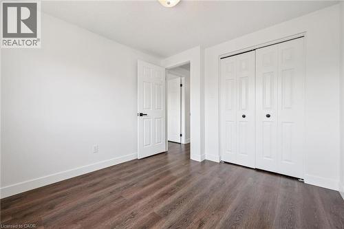 Room featuring wood-finish flooring, white walls, and a white ceiling with a flush-mount light fixture - 71 Peach Blossom Crescent, Kitchener, ON - Indoor Photo Showing Other Room