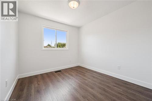 Room featuring wood-finish flooring, white walls, and bright overhead lighting - 71 Peach Blossom Crescent, Kitchener, ON - Indoor Photo Showing Other Room