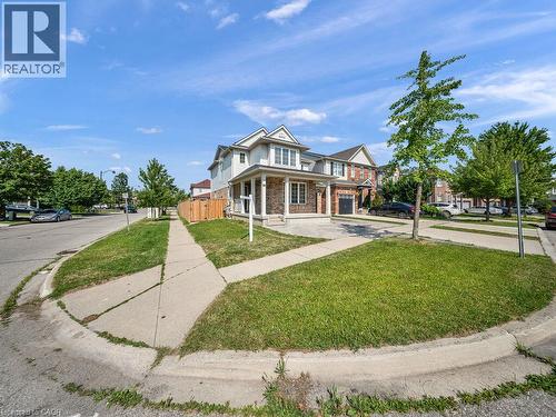 Two-story residence featuring a brick and siding exterior, a covered front porch with white pillars, and a paved driveway - 39 Baintree Way, Cambridge, ON - Outdoor