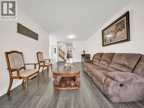 Spacious interior featuring wood-finish flooring, white walls, and a visible staircase with wood newel posts and handrails - 39 Baintree Way, Cambridge, ON - Indoor Photo Showing Living Room