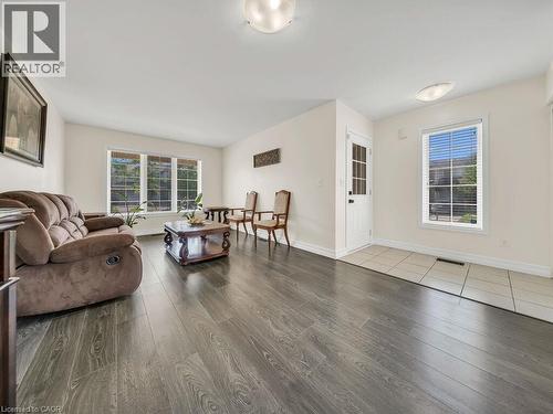 Spacious living area featuring wood-finish flooring, bright white walls, and multiple windows - 39 Baintree Way, Cambridge, ON - Indoor Photo Showing Living Room