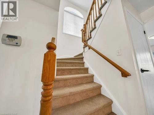 Carpeted staircase featuring a wood-finish banister and balusters - 39 Baintree Way, Cambridge, ON - Indoor Photo Showing Other Room