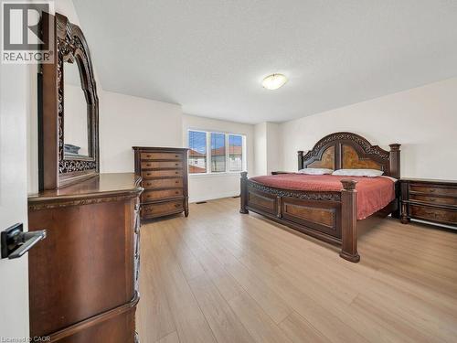 Spacious room featuring light wood-finish flooring, white walls, and a large window with horizontal blinds - 39 Baintree Way, Cambridge, ON - Indoor Photo Showing Bedroom