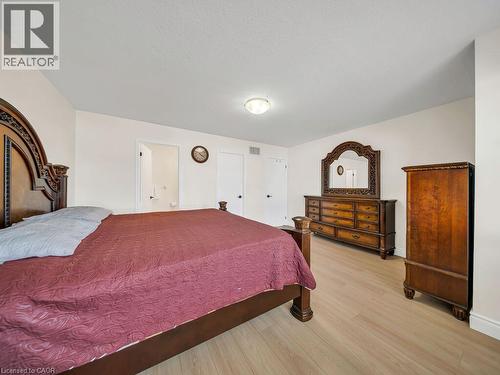 Light wood-finish flooring complements the neutral wall color in this room - 39 Baintree Way, Cambridge, ON - Indoor Photo Showing Bedroom