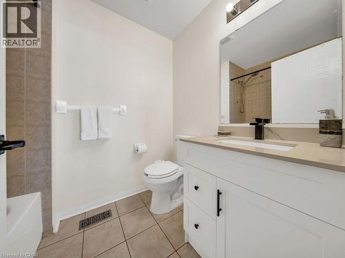 Bathroom featuring a white vanity with a stone-finish countertop, undermount sink, and matte black faucet - 39 Baintree Way, Cambridge, ON - Indoor Photo Showing Bathroom