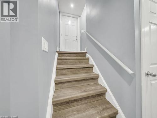 Staircase featuring wood-finish treads, a white handrail, and light gray wall paint - 39 Baintree Way, Cambridge, ON - Indoor Photo Showing Other Room