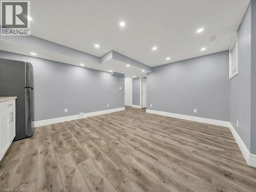 Spacious room featuring wood-finish flooring, light gray walls, recessed ceiling lighting, and white baseboards - 39 Baintree Way, Cambridge, ON - Indoor Photo Showing Other Room