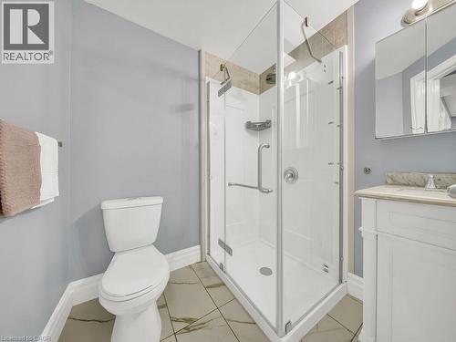 Contemporary bathroom featuring a glass-enclosed shower with a white base, a white vanity with a light-toned countertop, and patterned floor tiling - 39 Baintree Way, Cambridge, ON - Indoor Photo Showing Bathroom