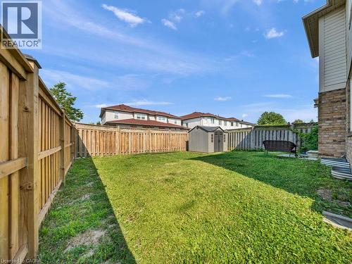 Private backyard featuring a wooden privacy fence, a storage shed, and a manicured lawn - 39 Baintree Way, Cambridge, ON - Outdoor
