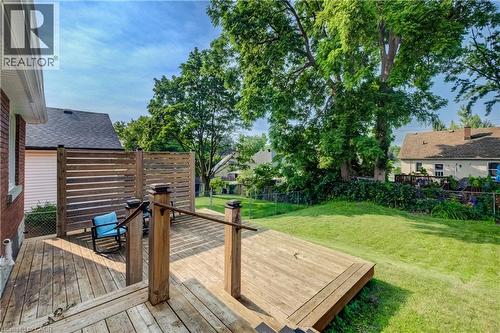Multi-level wood deck featuring built-in privacy screens and stairs descending to a sloped grassy yard with mature trees - 55 Rex Drive, Kitchener, ON - Outdoor With Deck Patio Veranda