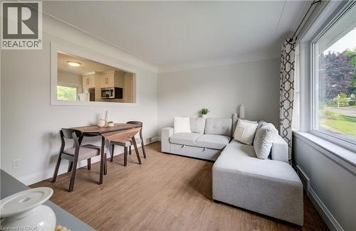 Spacious living area featuring wood-finish flooring and light grey wall tones - 55 Rex Drive, Kitchener, ON - Indoor