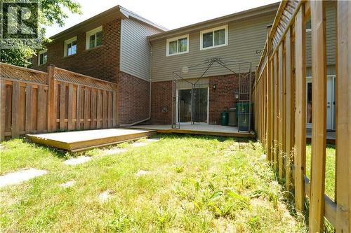 Fenced backyard with a wooden deck, sliding glass doors, and brick exterior - 136 Jansen Avenue, Kitchener, ON - Outdoor With Exterior
