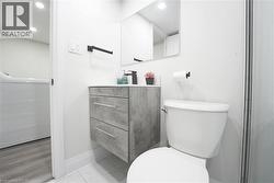 Bathroom featuring a floating vanity with a light gray countertop and a black single-handle faucet - 