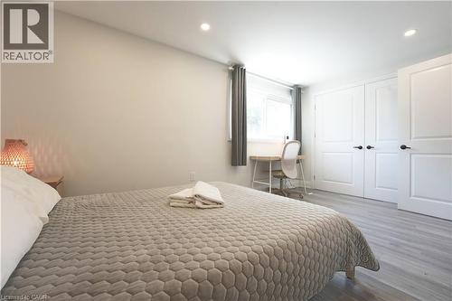 Bedroom featuring light gray wood-finish flooring, recessed lighting, and a window with gray drapes - 136 Jansen Avenue, Kitchener, ON - Indoor Photo Showing Bedroom