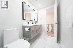 Modern bathroom featuring a floating double vanity with a light gray wood-grain finish, dual vessel sinks, and matte black fixtures - 