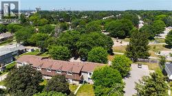 Townhome complex featuring dormer windows, brown shingle roofing, and individual front entrances - 