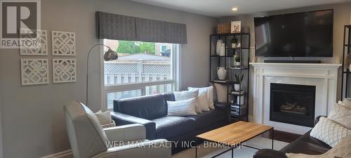 motororized blinds in family room hardwood floors - 22 Ashbury Crescent, Caledon, ON - Indoor Photo Showing Living Room With Fireplace