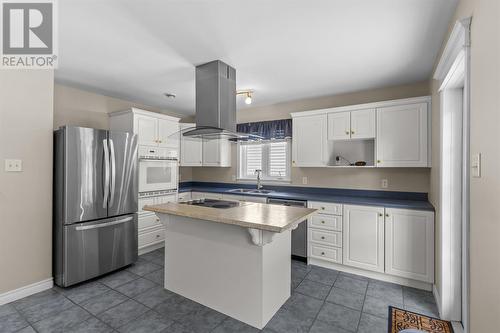 A large centre island with a newly installed stainless steel exhaust fan in 2019 creates the perfect gathering place. - 21 Westbrook Landing, Mount Pearl, NL - Indoor Photo Showing Kitchen With Double Sink