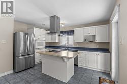 A large centre island with a newly installed stainless steel exhaust fan in 2019 creates the perfect gathering place. - 