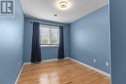 Bright secondary bedroom with hardwood flooring. - 
