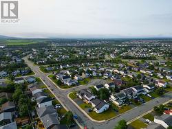 Expansive aerial view showcasing the neighbourhood, nearby amenities, and surrounding landscape. - 