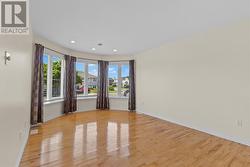 Sun filled living room featuring beautiful hardwood flooring and a large Bay Window. - 