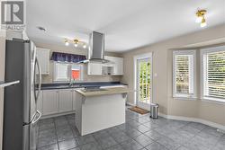 Functional kitchen with centre island and convenient patio access. - 