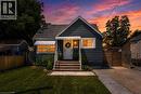 Charming bungalow exterior featuring horizontal siding and a prominent front entry with a white door - 621 Tate Avenue, Hamilton, ON  - Outdoor 