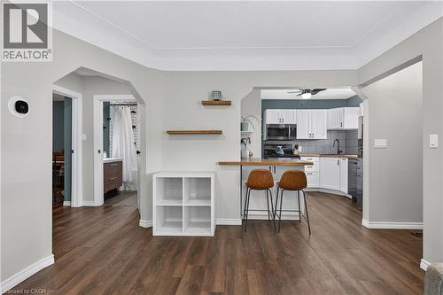 Open-concept living area featuring wood-finish flooring, light gray walls, and white baseboards - 621 Tate Avenue, Hamilton, ON - Indoor Photo Showing Kitchen