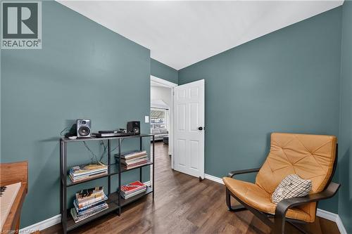 Interior space featuring wood-finish flooring, white baseboards, and a white six-panel door with black hardware - 621 Tate Avenue, Hamilton, ON - Indoor