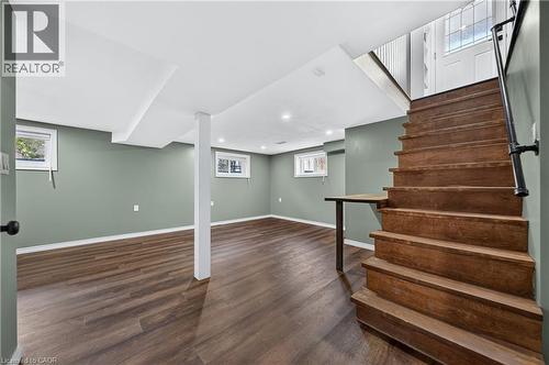 Finished lower level featuring recessed lighting, wood-finish flooring, and a built-in wooden table under the staircase - 621 Tate Avenue, Hamilton, ON - Indoor Photo Showing Basement