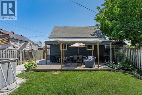 Expansive backyard featuring a manicured lawn, a wooden deck, and a covered patio area - 621 Tate Avenue, Hamilton, ON - Outdoor With Deck Patio Veranda