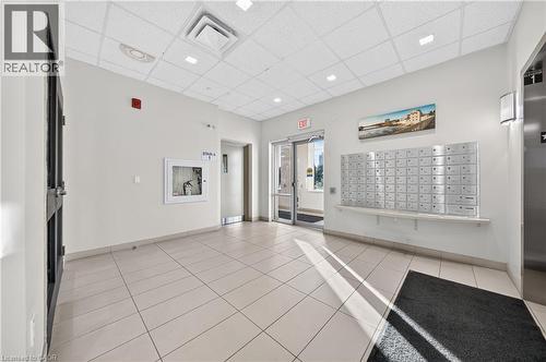 Building entryway featuring light-toned tile flooring, recessed ceiling lighting, and a wall of individual mailboxes - 155 Water Street S Unit# 203, Cambridge, ON - Indoor Photo Showing Other Room