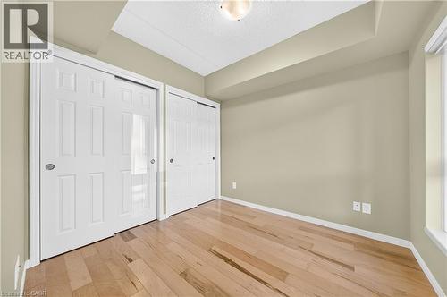 Light wood-finish flooring complemented by neutral wall tones - 155 Water Street S Unit# 203, Cambridge, ON - Indoor Photo Showing Other Room
