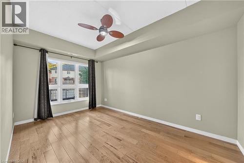 Room featuring wood-finish flooring, a multi-pane window, and a ceiling fan with integrated lighting - 155 Water Street S Unit# 203, Cambridge, ON - Indoor Photo Showing Other Room