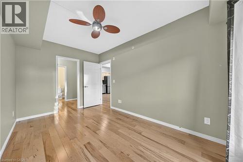 Spacious room featuring wood-finish flooring, a ceiling fan with wood-tone blades, and neutral-toned walls - 155 Water Street S Unit# 203, Cambridge, ON - Indoor Photo Showing Other Room