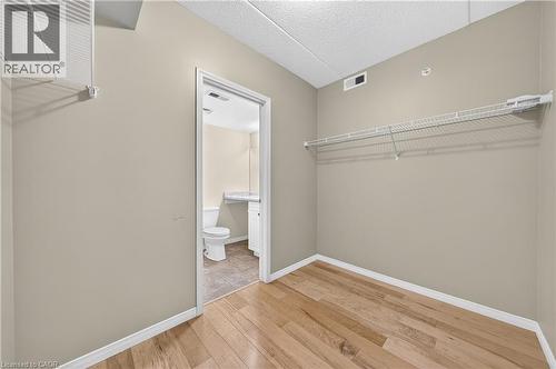 Room featuring wood-finish flooring, neutral wall paint, and white wire shelving - 155 Water Street S Unit# 203, Cambridge, ON - Indoor