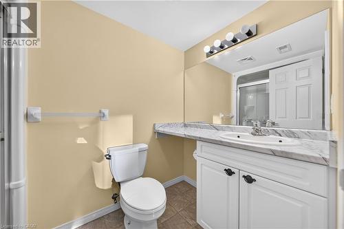 Vanity with white cabinetry, stone-finish countertop, and integrated sink - 155 Water Street S Unit# 203, Cambridge, ON - Indoor Photo Showing Bathroom