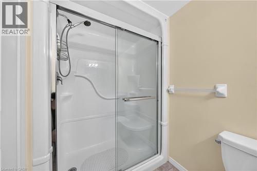 Enclosed shower stall with sliding glass doors, integrated shelving, and a handheld showerhead - 155 Water Street S Unit# 203, Cambridge, ON - Indoor Photo Showing Bathroom