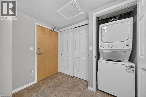 Entryway featuring tile flooring, a light wood-finish door, and white painted trim - 155 Water Street S Unit# 203, Cambridge, ON - Indoor Photo Showing Laundry Room