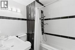 Contemporary bathroom featuring a white tile surround with black accent bands - 