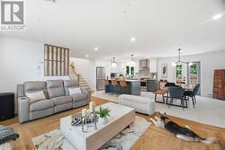 Open concept entertaining area with modern kitchen, dining room and living room. - 