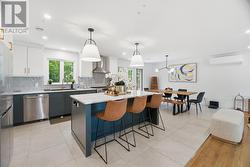 Open-concept kitchen with stone countertop island and dining room - with patio access - 